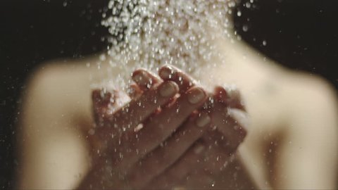 woman taking a shower in slow motion. beautiful girl enjoying the water drops on her hands and throwing the water on herself