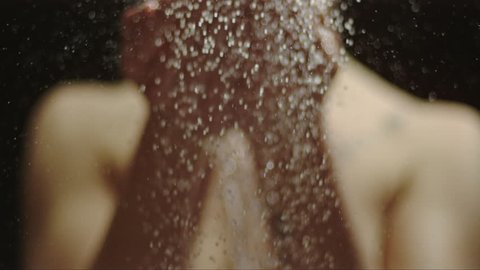 woman taking a shower in slow motion. beautiful girl enjoying the water drops on her hands and throwing the water on herself