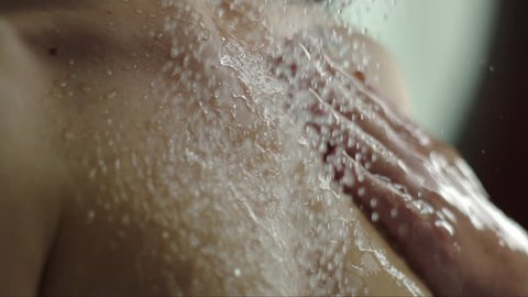 woman taking a shower in slow motion. beautiful girl washing and enjoy herself under a shower, close up of the hands, back and chest