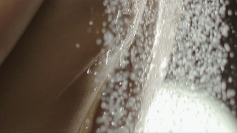 woman taking a shower in slow motion. beautiful girl washing and enjoy herself under a shower, close up of the hands, back and chest