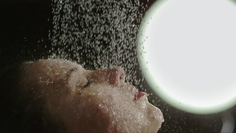 woman taking a shower in slow motion. close up of a face of a beautiful girl enjoying the water on her face. 