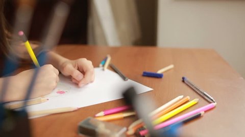 The child draws with pencils. close-up