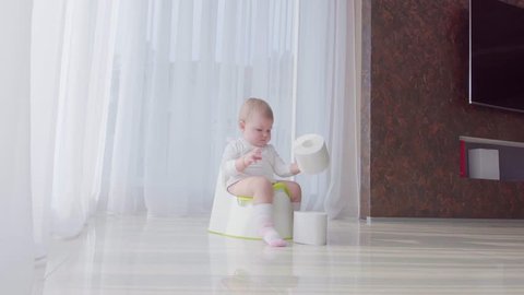 Small child sits on the potty and relieves itself