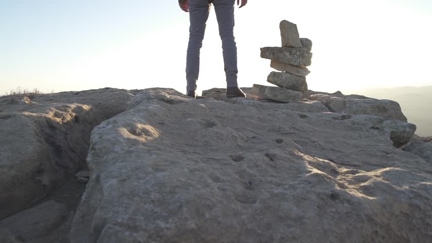 Man standing on top of a desert cliff in the morning sun