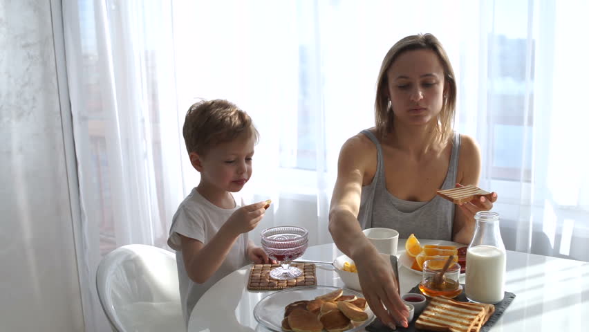 young girl and cute boy eating Breakfast. eat toast and pancakes Royalty-Free Stock Footage #25195025