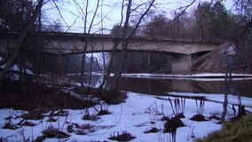 Winter forest and the river on the background of the bridge. Time lapse video full hd.