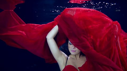 Ecstasy in motion under water. Sexy dance young beautiful girl in zero gravity. Red long dress