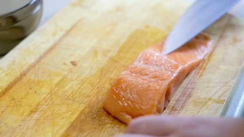 The chef cuts salmon fillets for cooking