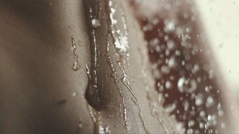woman taking a shower in slow motion. young girl under shower playing and enjoy water on her tummy.