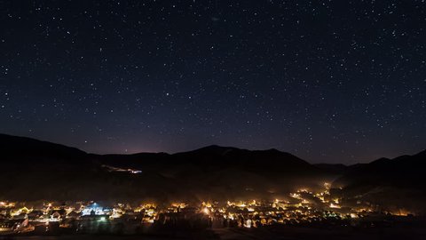 Night traffic in village and street lights under starry sky time lapse

