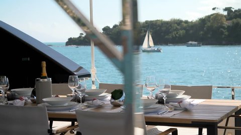 Table set for lunch on a luxury yacht docked in the bay in front of Portovenere, Italy
