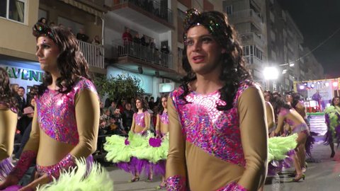 Men impersonating singer Jennifer Lopez parade and dance during Carnival of Aguilas with costumes and feathers. A party with international tourist interest. Aguilas, Spain February 26th, 2017.