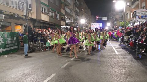 Men impersonating singer Jennifer Lopez parade and dance during Carnival of Aguilas with costumes and feathers. A party with international tourist interest. Aguilas, Spain February 26th, 2017.