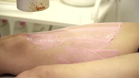 Beautician removing leg hair with wax, closeup