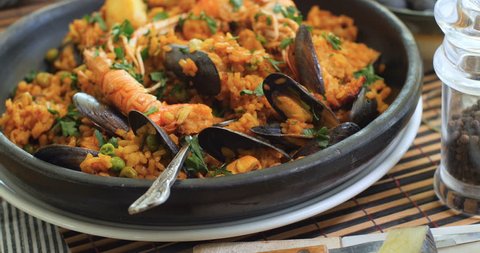 Dolly close up push in view of a Spanish seafood paella: mussels, king prawns, langoustine, haddock