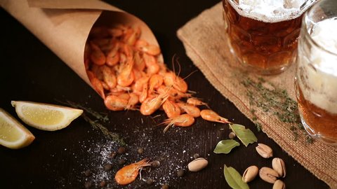 Fills the glass of Beer mug and grilled shrimps on wooden table