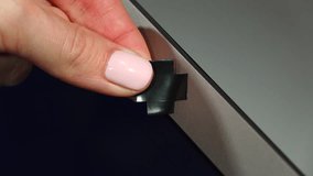 Fear of spying and peeping using malicious program through web camera of laptop, woman use black opaque tape to close lens hole. Inexperienced user have anxiety while going online - Powered by Shutterstock - Get 15% off with code: PIKWIZARD15