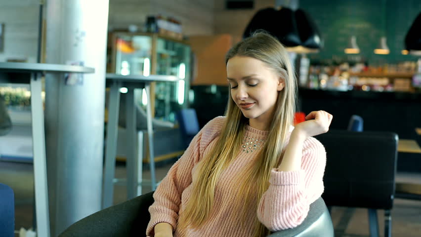 Pretty girl spinning on the swivel chair and smiling to the camera
