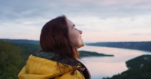 Close up of beautiful young woman looking up at sky out towards horizon view on top of mountain enjoying mindfulness spiritual moment in nature
