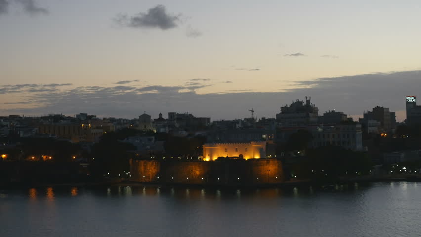 Establishing shot-Ship view passing La Fortaleza Historic site San Juan Puerto Rico pre-dawn light