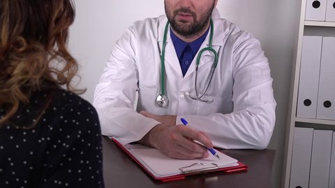 Male doctor writing medical notes about patient disease illness confident medic 