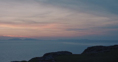 Woman with arms raised on top of mountain looking at Sunset view over ocean Hiker Girl celebrating scenic landscape enjoying nature vacation travel adventure Isle of Skye Scotland