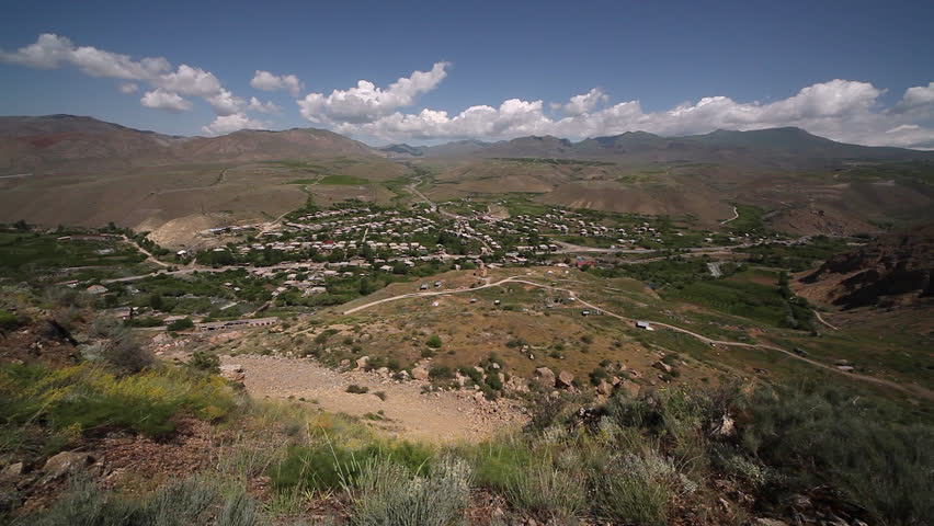 Aerial view of beautiful village or town surrounded by mountains, with highway going through