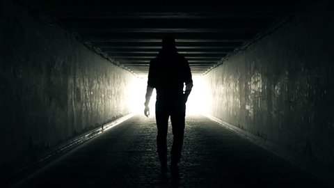 Slow Motion Video of Man walking in Tunnel to the Light