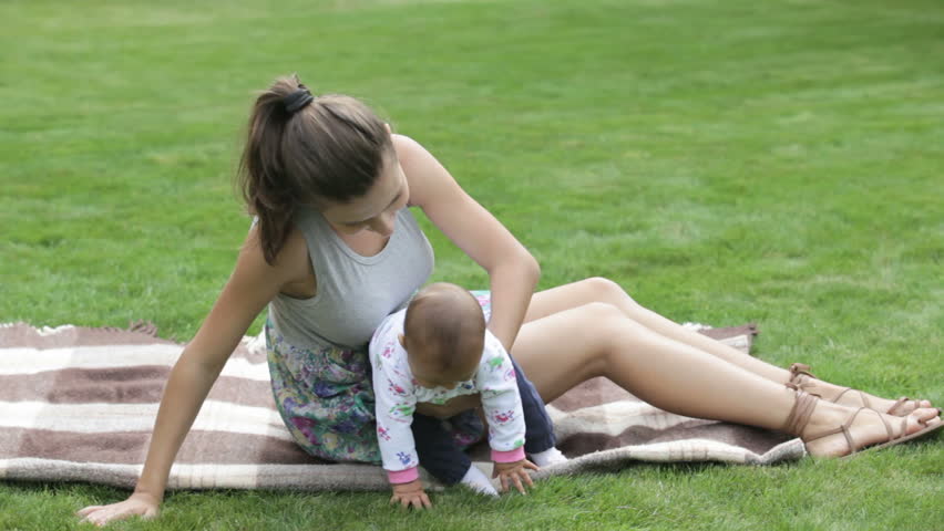 young girl playing with her baby child in nature