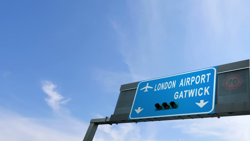 airplane flying over london gatwick airport sign