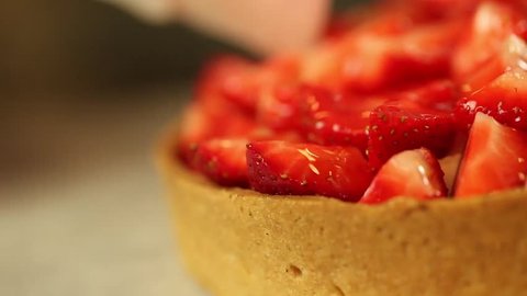 putting sugar gelatin on strawberry  tart pan left Stock-video