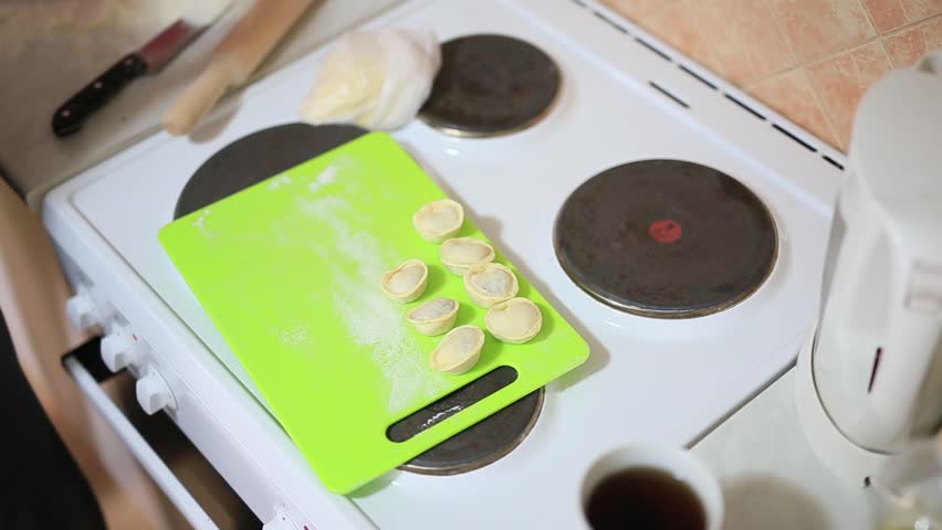 She sculpts dumplings in the kitchen. Girl cooking food.