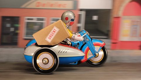 Tin toy delivery motorbike and sidecar speeding along a city street with an urgent parcel.