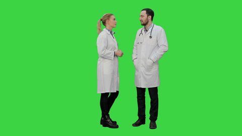Two professional doctors talk before operation on a Green Screen, Chroma Key.