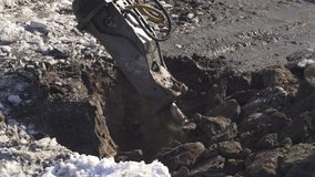 Breaker (hydraulic) cuts frozen soil. Stock footage video