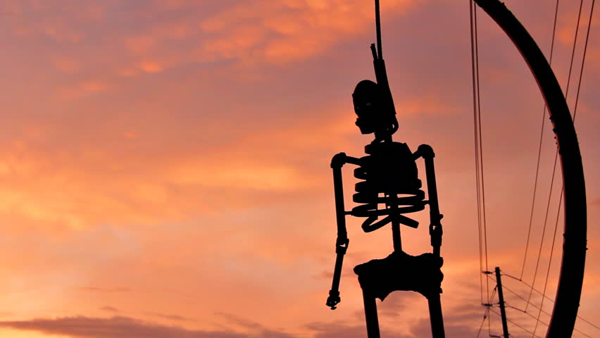 Hanging Skeleton Sunset. Rusted metal skeleton silhouette hanging from a noose