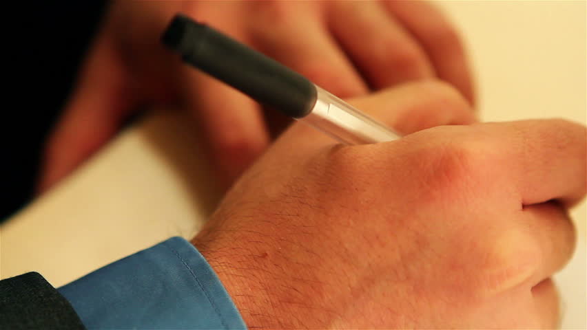 Male hands writing on a paper