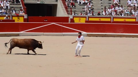 PAMPLONA, SPAIN - JULY 2016. A bull trimmer leaps over the head of the bull or twists his body as the bull passes by in the bull ring of Pamplona during San Fermin running of the bulls Festival
