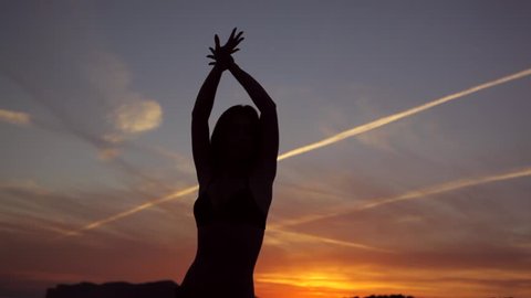 girl dancing silhouette at sunset sea bay