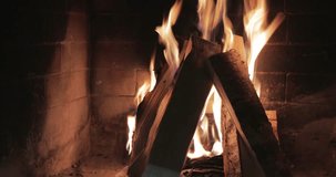 4K video, a large fire in a brick fireplace, a romantic evening, the smell of fire, firewood, briquettes for fireplaces, charcoal, Red coals, pleasant crackle of firewood, Real firewood