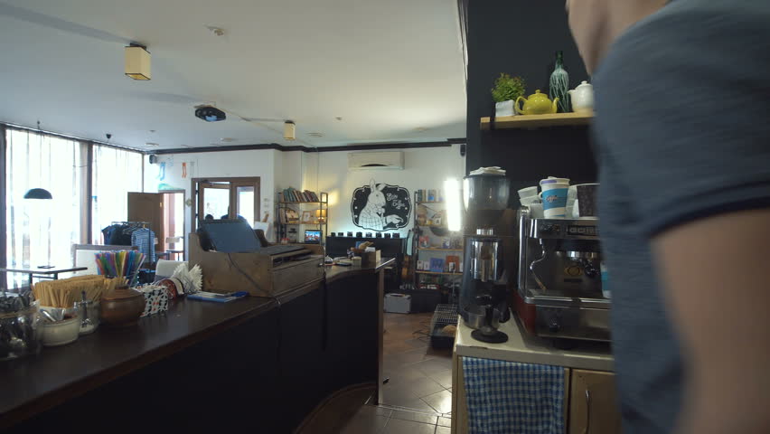 Two African and Caucasian people walking into the shop and aiming to the assistant with guns. 4K gimbal stabilized shot