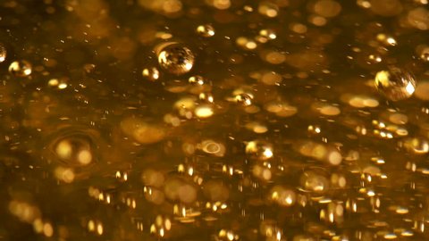 A lot of bubbles in the yellow liquid, slowly rising and bursting, liquid is like beer or oil or drink or fuel, can be applied in any version