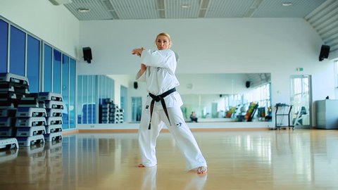 Young woman training the karate tricks in the gym