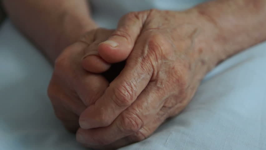 A young hand comforting an elderly pair of hands.