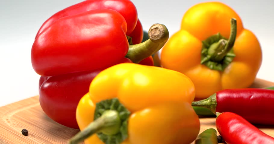 Fresh vegetables: orange and red peppers, green and red chili peppers, jalapeno, cherry, black pepper on a wooden board on a white background. Slider movement. Shallow depth of field. Focus on peppers Royalty-Free Stock Footage #25336664