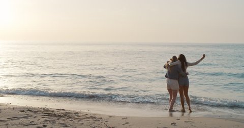 Two young woman arms raised discovering beautiful tropical beach teenager girls enjoying nature together as best friends celebrating summer vacation