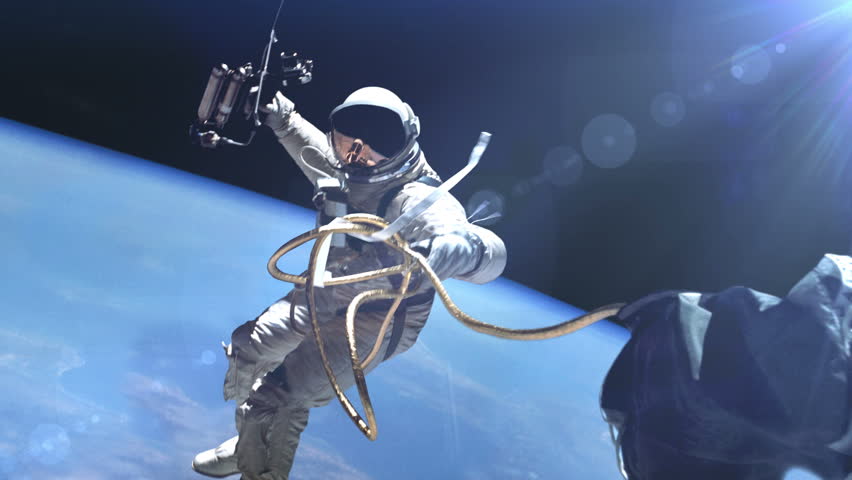 Astronaut in outer space against the Earth background. Elements of this image furnished by NASA. Royalty-Free Stock Footage #25339733