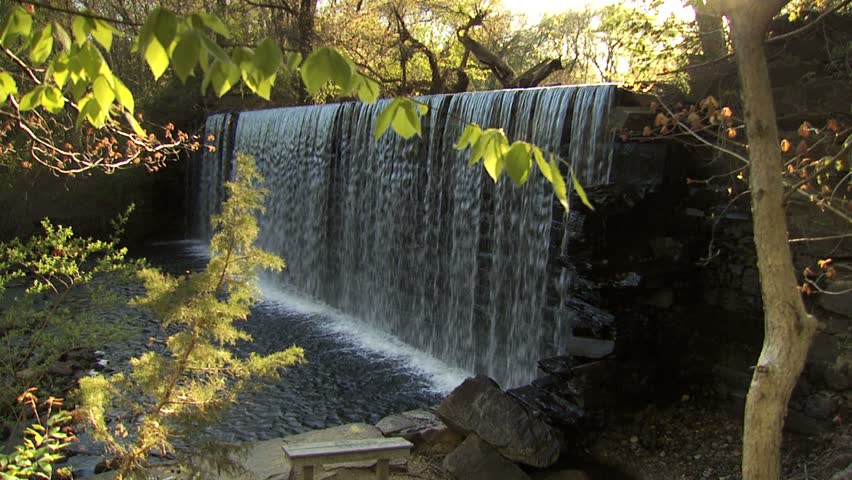 Waterfall at old textile mill with trees in foreground - 1