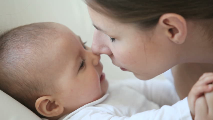 young pretty mother kissing her little baby with love