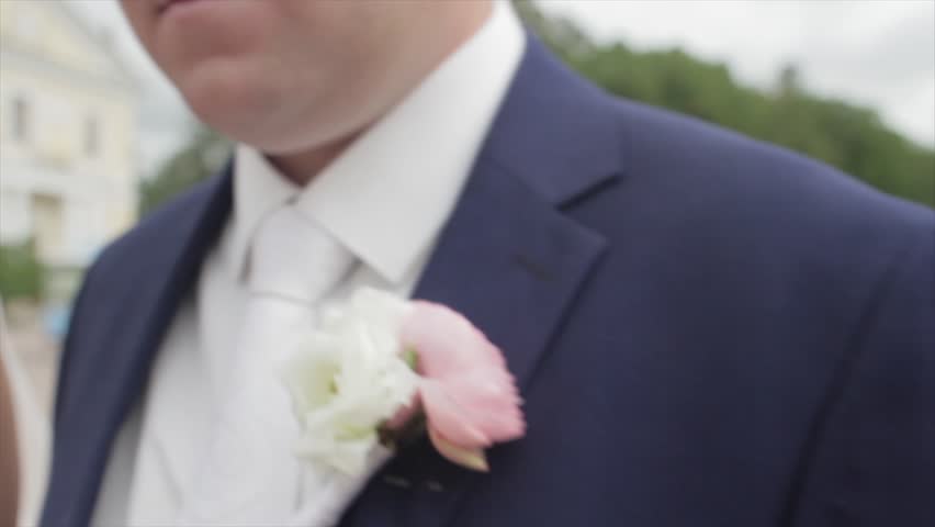 Young newlyweds walking outside. The bride and groom walk together in the Park in winter or summer and holding hands. happy bridal couple walking in park among the bushes cherry. Bride and groom